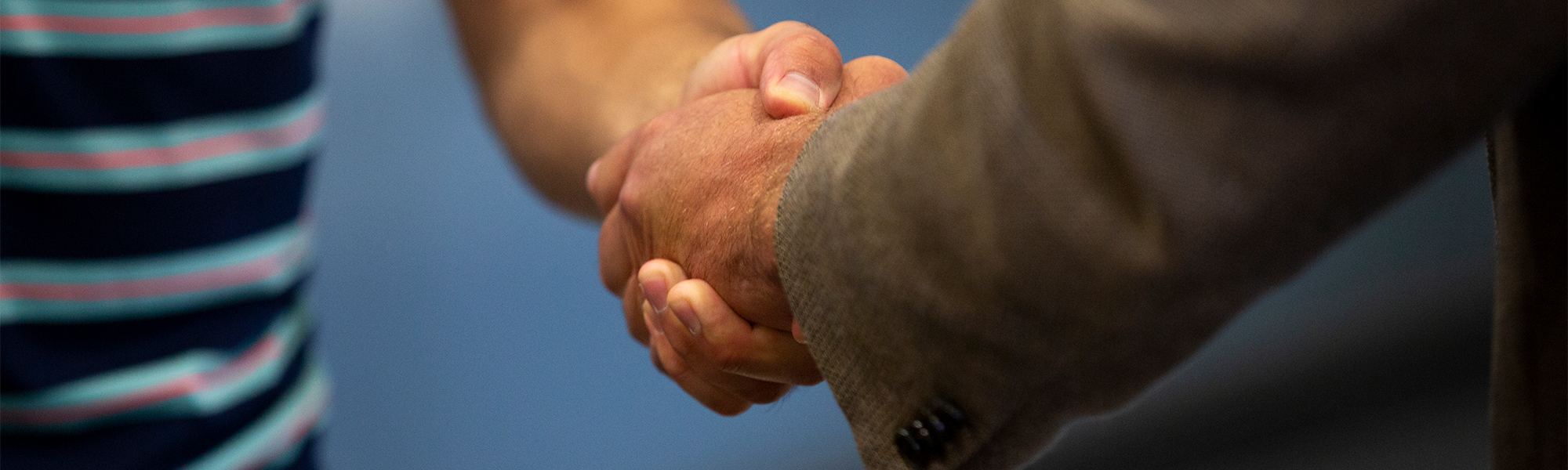 CU Boulder alumni shaking hands